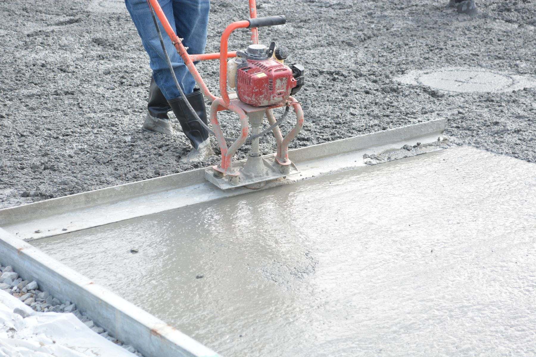 Fresh concrete being leveled and finished, as when a slab is patched after a leak repair