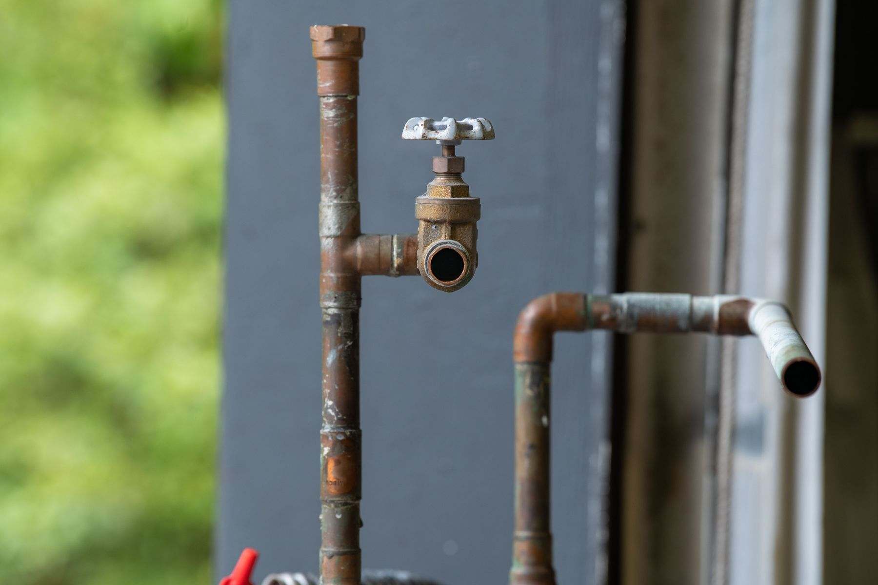 Copper supply pipe with a shutoff valve, the kind of line run through a wall when a slab leak is rerouted