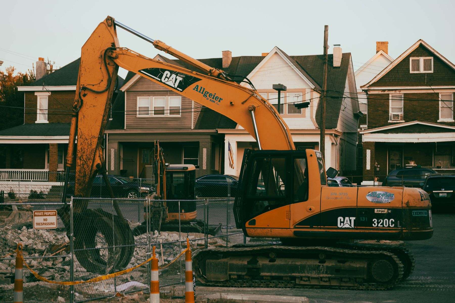 Water line repair Tangent OR: an excavator digging in front of homes to reach a buried line