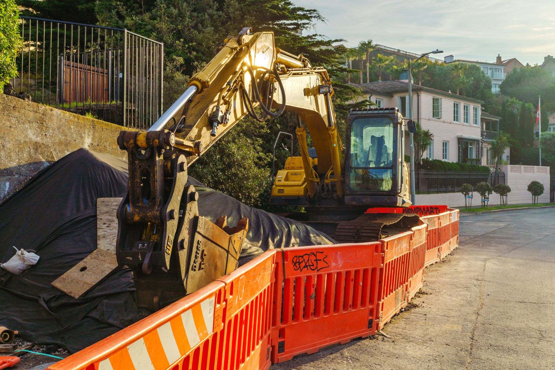 Water line repair Millersburg OR: an excavator behind barricades on a residential street