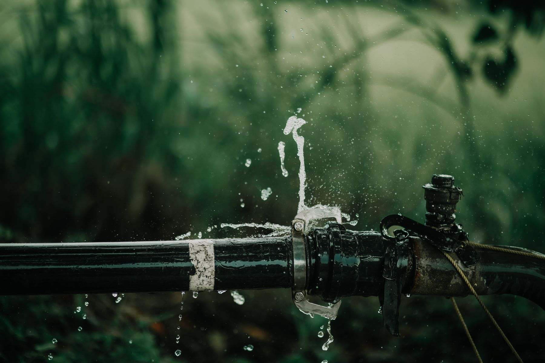 Water leak detection Albany OR: a buried supply pipe spraying water through a split joint