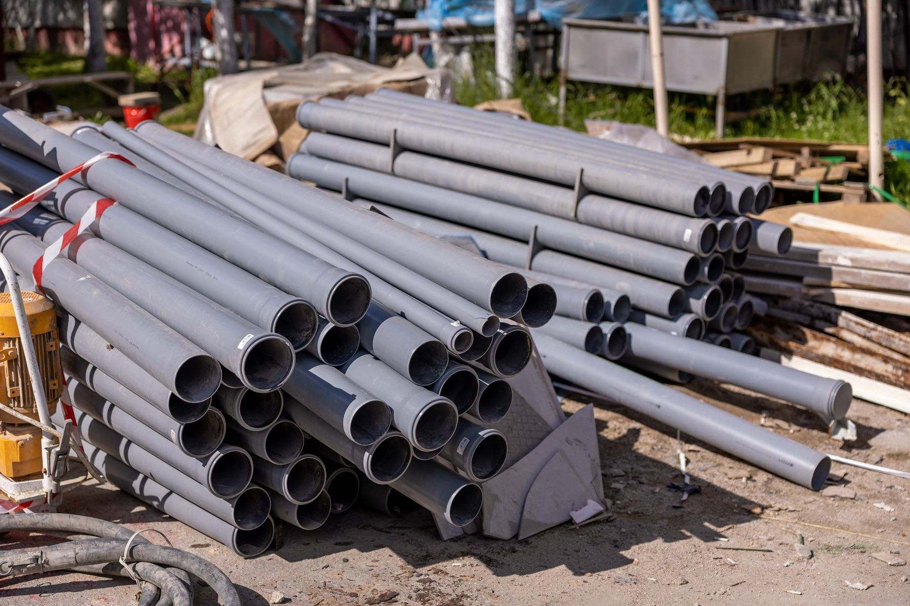 Stacked PVC pipe at a job site, one of the materials used for a new water service line